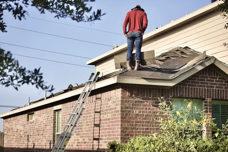 Professional roofer working on a residential roof in Goodluck